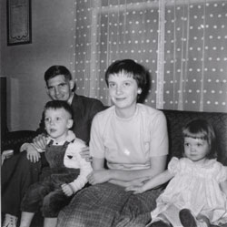 Jeune homme et femme assis sur un divan avec un petit garçon et une fille. 