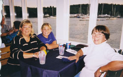 Irene, Fiona et Sarah assises à une table de restaurant avec une nappe mauve.