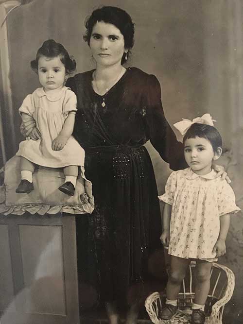 Le portrait noir et blanc de femme étant debout avec deux enfants a placé à côté d'elle