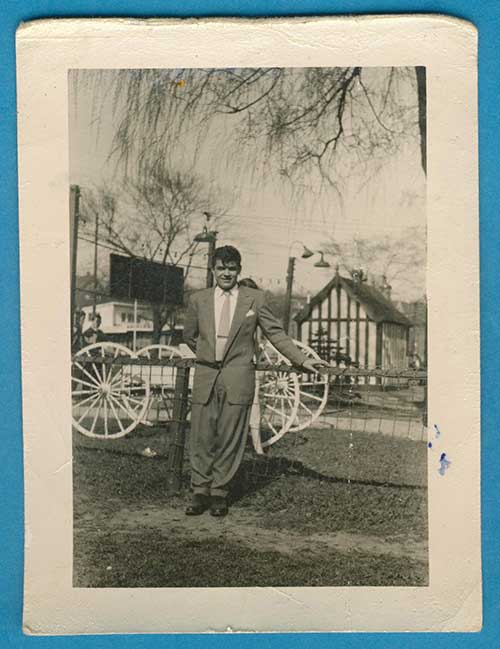 Un jeune homme se tient à côté d’une rambarde.