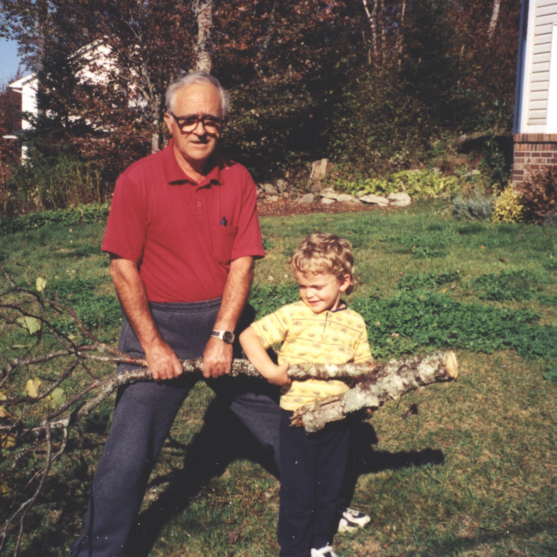 Jeune garçon et l'homme transportant branche d'arbre.