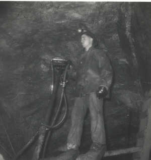 Jeune homme travaillant avec de l’équipement dans une mine souterraine.