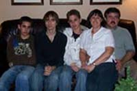 Photo récente en couleur de cinq membres de la famille Damiani assis sur le canapé.