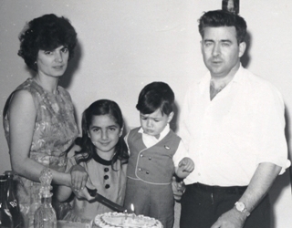 Un homme et une femme debout avec deux petits enfants entre eux.
