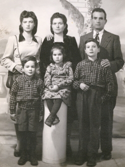 Portrait de famille avec trois enfants devant et trois adultes derrière.