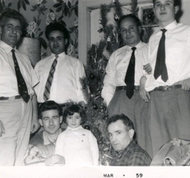 Deux hommes assis avec un petit enfant, quatre hommes en chemise blanche et cravates debout derrière eux.