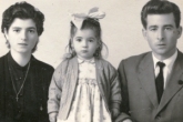 Jeune fille avec grand arc sur la tête, mère et père de chaque côté.
