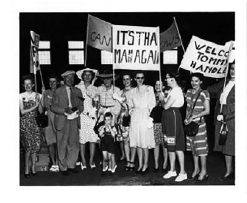 Image d’archives montrant plusieurs personnes brandissant des panneaux de bienvenue