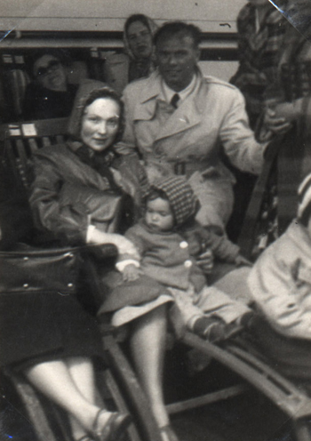 Mère et bébé assis dans un fauteuil de pont, entourés par d’autres passagers.