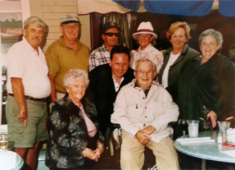 Un groupe de membres de la famille est assis et debout pour une photo.