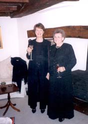 Mère et fille adulte, portant des robes noires et tenant des verres à vin.