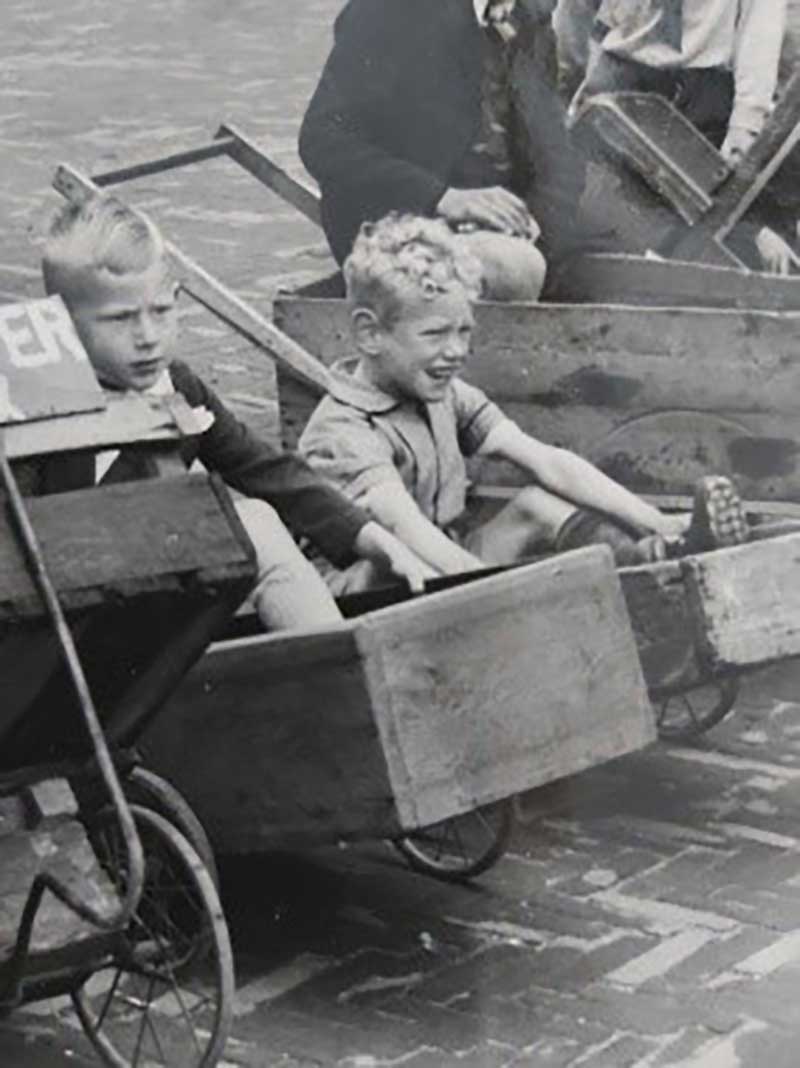 Deux jeunes garçons assis dans des paniers faits à la main.
