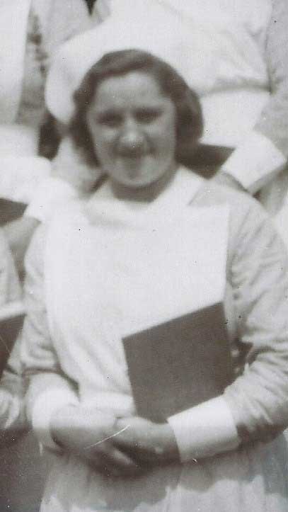 Une jeune femme en uniforme d’infirmière tient un livre à la main.