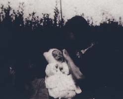 Vieille photo en noir et blanc d’un petit bébé en blanc.