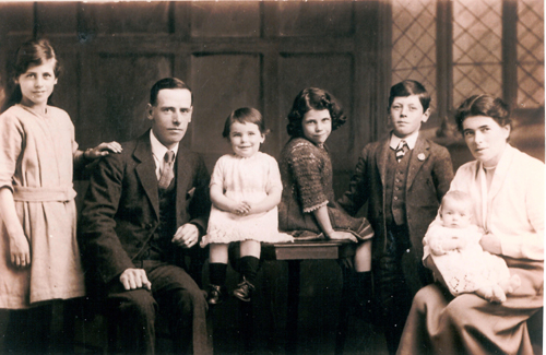 Portrait de famille d’un homme et d’une femme et cinq enfants d’âges variés.