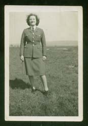 La jeune Joan en tenue militaire, debout au loin à l’extérieur. 