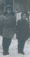 Garçon et fille en vêtements d’hiver, debout dans la neige.