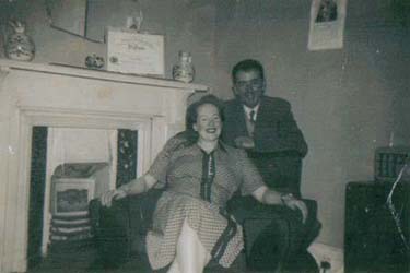 Homme et femme assis devant la cheminée.