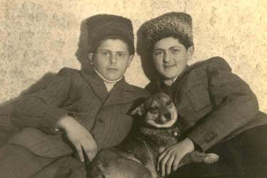 Deux jeunes garçons portant des chapeaux de fourrure, un chien entre eux.