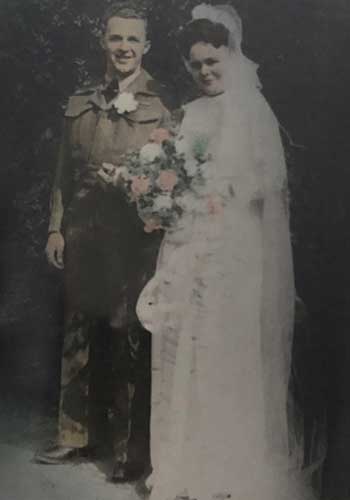 Portrait d’archives d’une mariée et le marié le jour de leur mariage, la mariée tient un beau bouquet de fleurs roses et blanches.