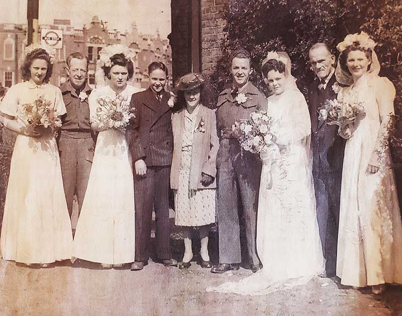 Photographie sépia montrant plusieurs membres d’un entourage nuptial le jour d’un mariage.
