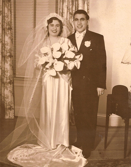 Une mariée tenant des fleurs se tient avec le marié pour une photo.