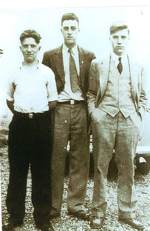 Trois hommes debout posent pour la photo.