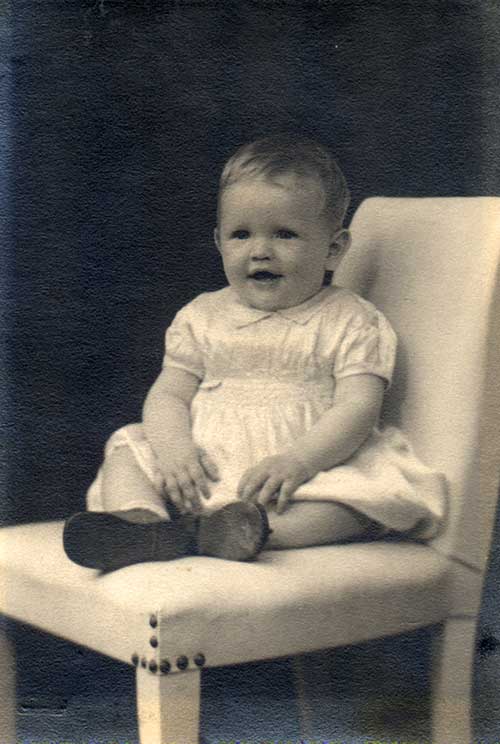 Petite fille assise sur une chaise.