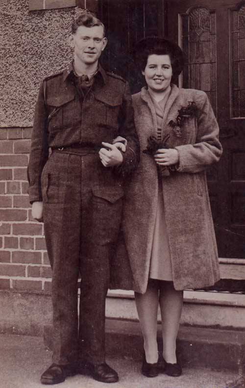Un jeune homme et une jeune femme se tiennent devant une porte.