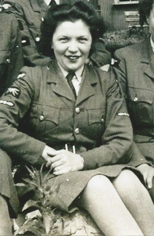 Une jeune femme en uniforme militaire est assise entre deux personnes.