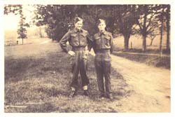 Le jeune Leland et son frère en tenue militaire, debout près d’un chemin de terre.