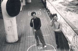 Deux jeunes hommes jouant sur le pont d’un bateau, à partir du niveau supérieur. 
