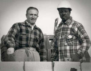 Deux hommes portant des vêtements de travail et des casques de protection.
