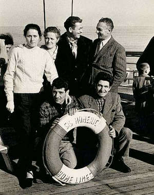Plusieurs jeunes gens derrière un sauveteur lisant SS Homeric.