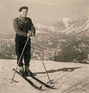 Jeune Leonardo avec des skis et des bâtons dans les Alpes, posant pour la caméra.
