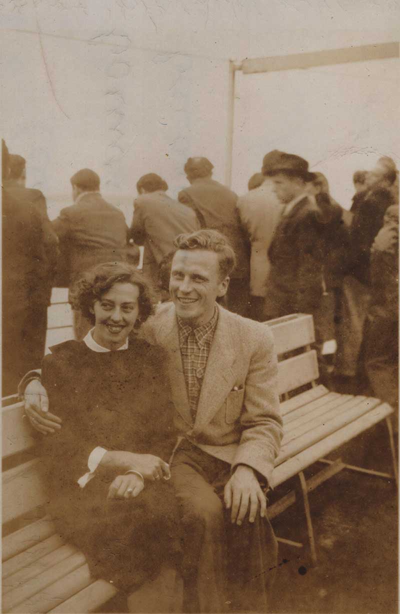 Image granuleuse d’un jeune couple assis sur les chaises longues d’un bateau.