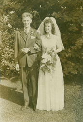Le jeune John avec son épouse, le jour du mariage, debout devant des arbres.