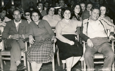 Deux hommes et deux femmes assis dans la première rangée de chaises.