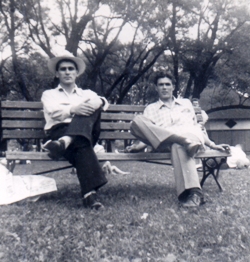 Deux jeunes hommes assis sur un banc de parc en été.