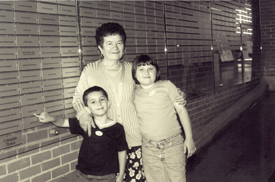 Maria avec deux petits-enfants devant le mur d’honneur du quai 21.