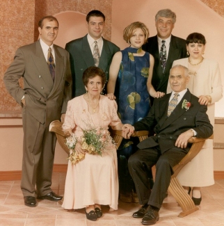 Photo en couleur d’un couple Pagano plus âgé, assis avec sa famille derrière.