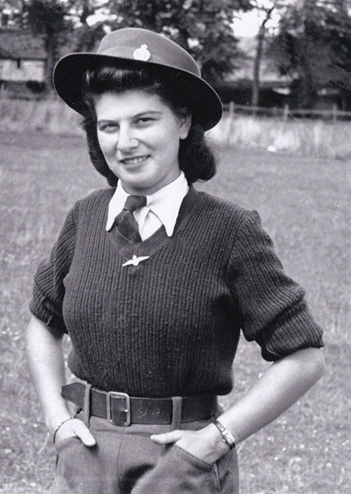 Une jeune femme porte un chapeau et a les mains dans les poches.
