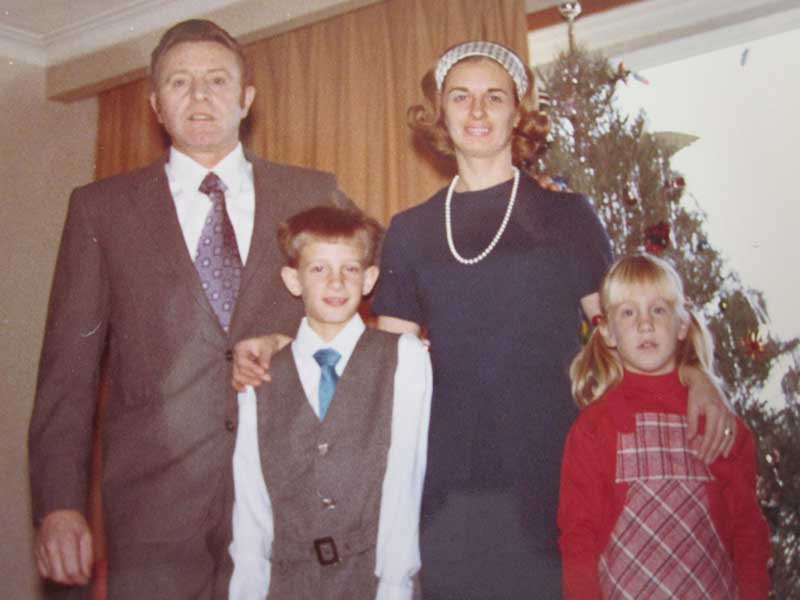 Un homme et une femme bien habillés posent pour la photo en compagnie de deux enfants.