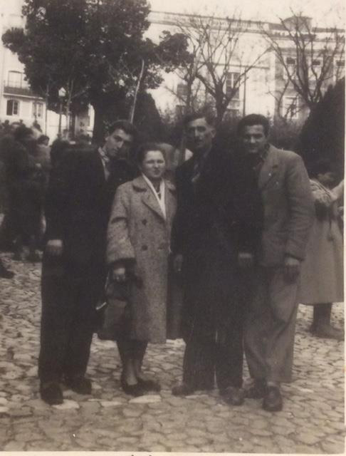 Une femme et trois hommes se tiennent debout et posent pour la caméra.