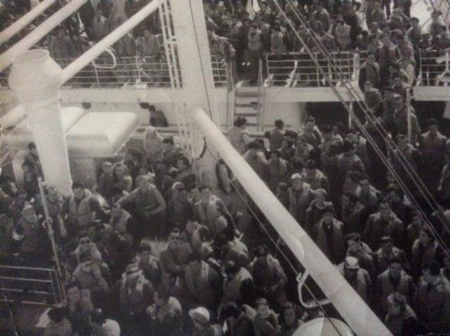 Grand groupe de personnes à bord d’un navire.