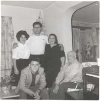 Deux membres de la famille assis avec trois debout à proximité.