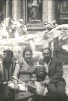 La famille Orlando assis sur le mur de pierre entourant la fontaine de Trevi.