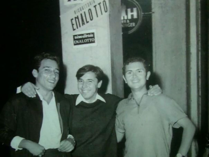 Image d’archives de trois jeunes hommes avec des bras l’un autour de l’autre.