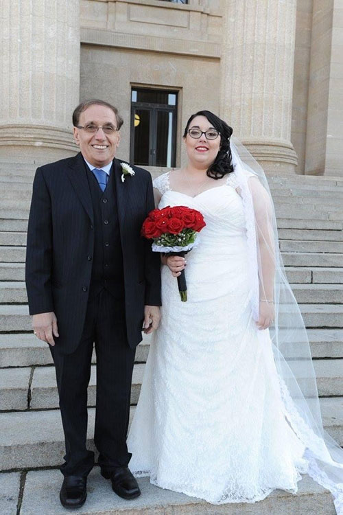 Un homme se tient à côté de sa fille devant une église, c’est le jour de son mariage.