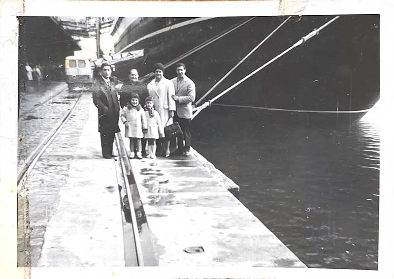 Une famille de six personnes se tient sur la jetée, attendant d’embarquer.